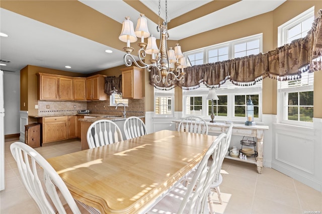 dining area with sink, light tile patterned flooring, and an inviting chandelier