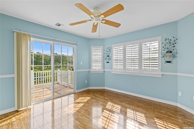 empty room featuring hardwood / wood-style floors, plenty of natural light, and ceiling fan