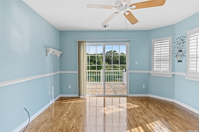 spare room featuring light wood-type flooring, a wealth of natural light, and ceiling fan