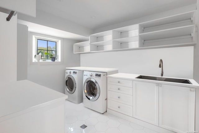 laundry room with cabinets, separate washer and dryer, and sink