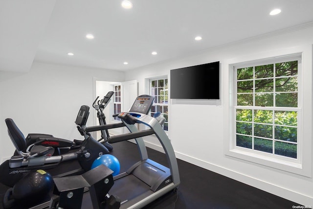 workout area featuring hardwood / wood-style flooring, ornamental molding, and a wealth of natural light