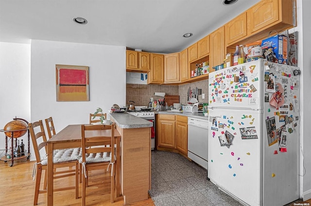 kitchen featuring wood-type flooring, white appliances, light brown cabinetry, and tasteful backsplash