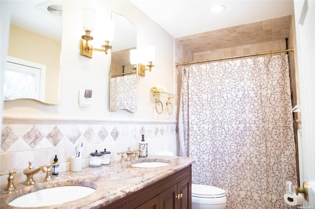 bathroom with vanity, toilet, and tile walls