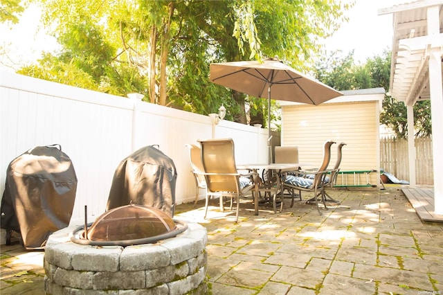 view of patio with a grill and an outdoor fire pit