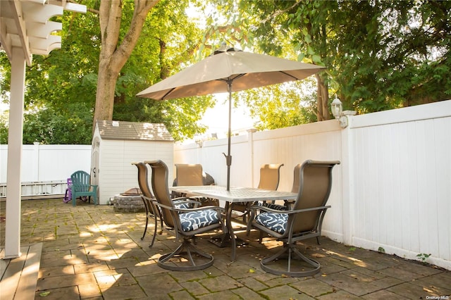 view of patio / terrace with a shed and an outdoor fire pit