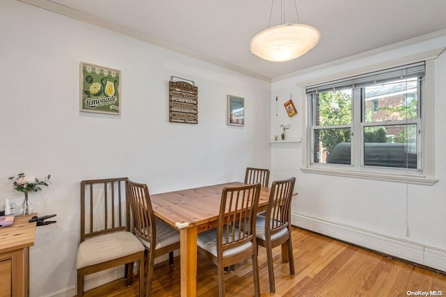 dining area with light wood-type flooring, a baseboard radiator, and ornamental molding