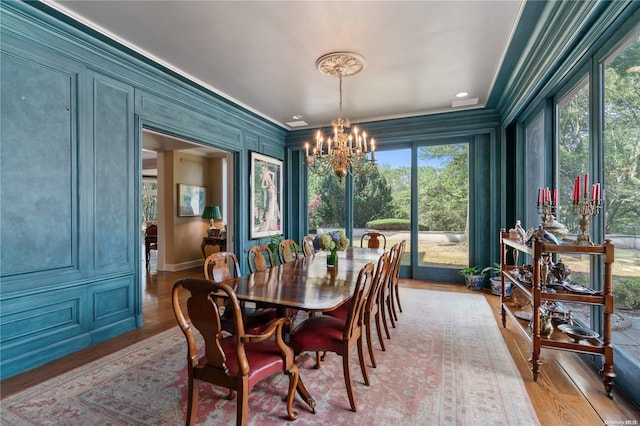 dining area with a chandelier, a wealth of natural light, crown molding, and light hardwood / wood-style floors