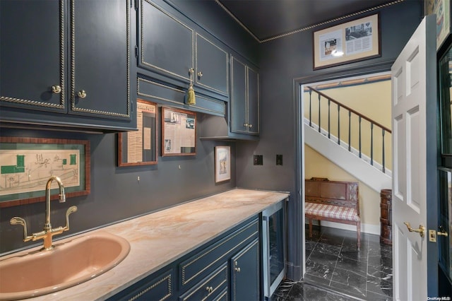 kitchen featuring blue cabinetry, wine cooler, and sink