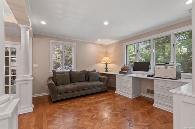 home office with built in desk, light parquet flooring, a healthy amount of sunlight, and ornamental molding