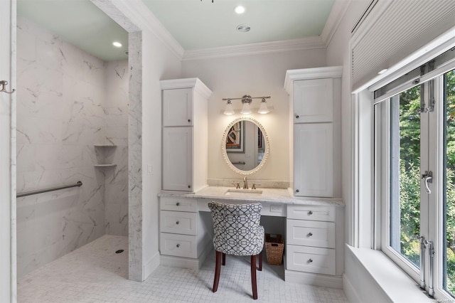 bathroom featuring tiled shower, a wealth of natural light, crown molding, and sink