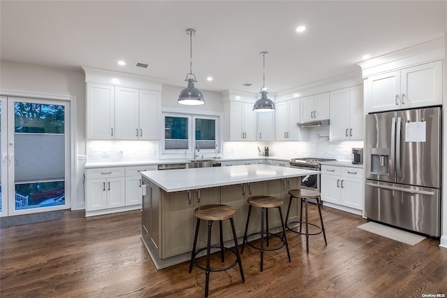 kitchen with stainless steel appliances, pendant lighting, a center island, dark hardwood / wood-style floors, and white cabinetry