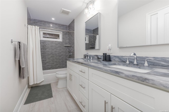 full bathroom with toilet, vanity, and shower / tub combo with curtain