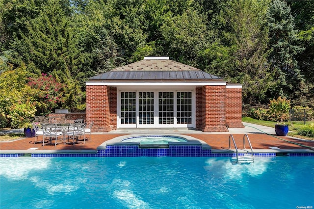 11 Dupont Ct, Brookville, NY 11548 - view of pool featuring a storage structure, an outdoor structure, a patio, a pool with connected hot tub, and a wooded view