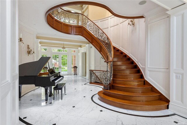 11 Dupont Ct, Brookville, NY 11548 - staircase featuring a decorative wall, crown molding, marble tiled floors, and french doors