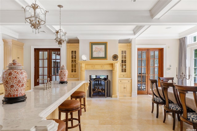 dining room with a notable chandelier, beam ceiling, ornamental molding, and french doors