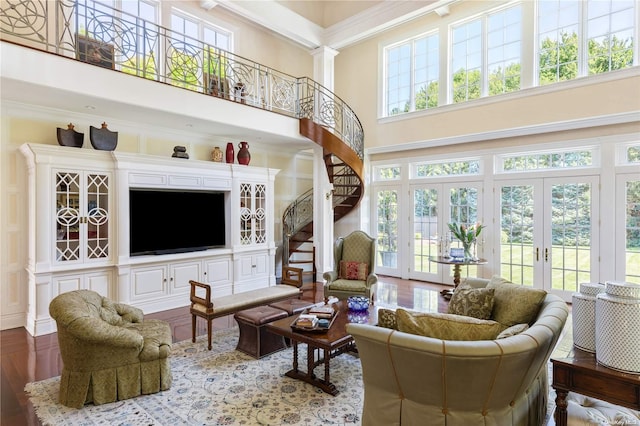 living room featuring french doors, a towering ceiling, wood-type flooring, and plenty of natural light