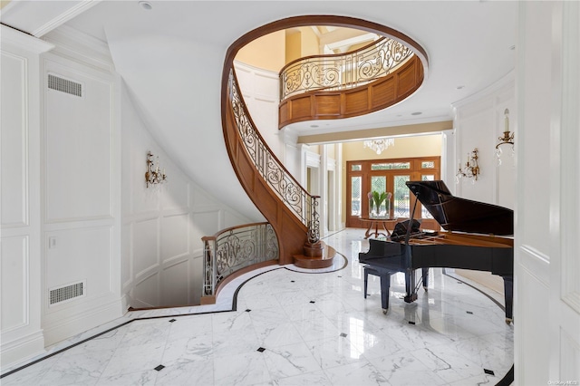 11 Dupont Ct, Brookville, NY 11548 - foyer entrance with a decorative wall, marble tiled flooring, ornamental molding, stairs, and a chandelier