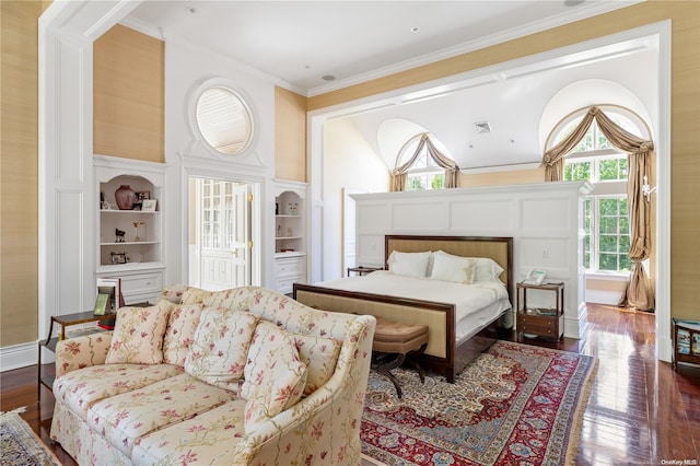 bedroom with a fireplace, hardwood / wood-style floors, and crown molding