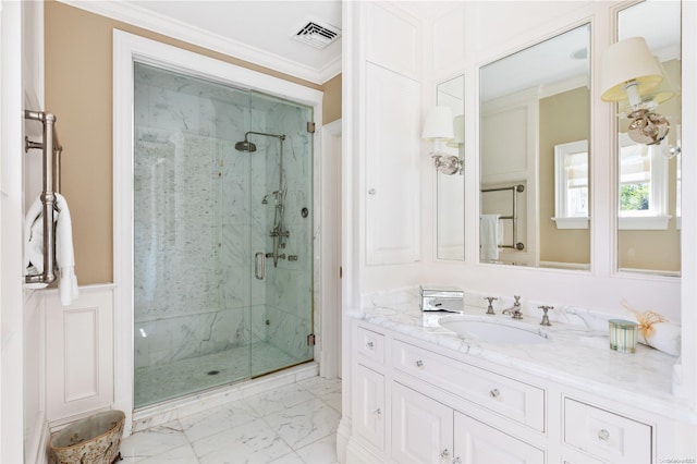 bathroom featuring vanity, a shower with shower door, and crown molding