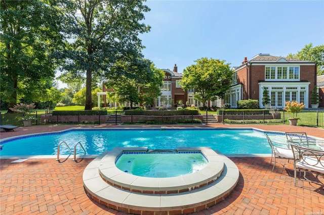 view of swimming pool featuring an in ground hot tub and a patio