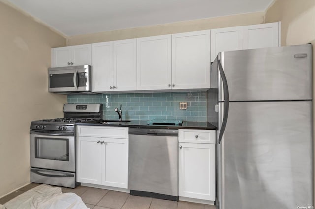 kitchen with white cabinets, sink, tasteful backsplash, light tile patterned flooring, and stainless steel appliances