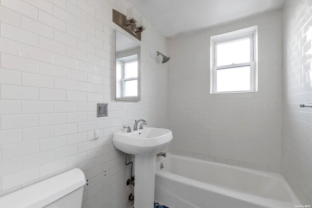 bathroom with toilet, tile walls, and a wealth of natural light