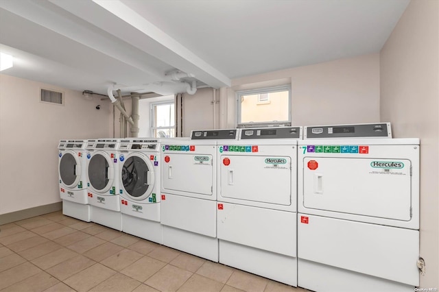 laundry room with washing machine and dryer and light tile patterned floors