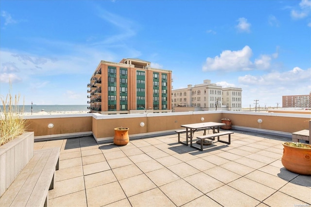 view of patio with a water view and a view of the beach