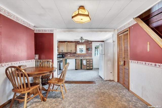 dining room featuring ceiling fan, light colored carpet, and ornamental molding