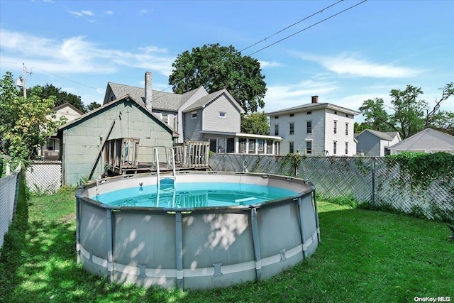 rear view of property featuring a lawn and a pool side deck