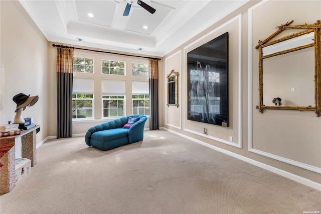 living area featuring a towering ceiling, light colored carpet, a raised ceiling, ceiling fan, and crown molding