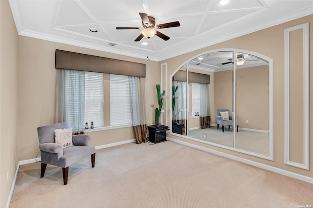 sitting room with ceiling fan, light colored carpet, coffered ceiling, and ornamental molding