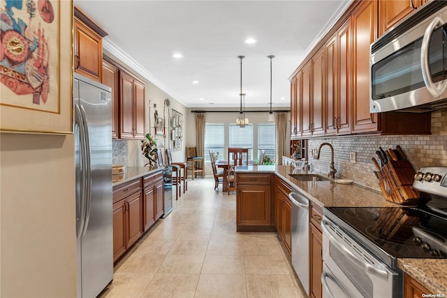 kitchen featuring sink, hanging light fixtures, stone countertops, light tile patterned flooring, and appliances with stainless steel finishes