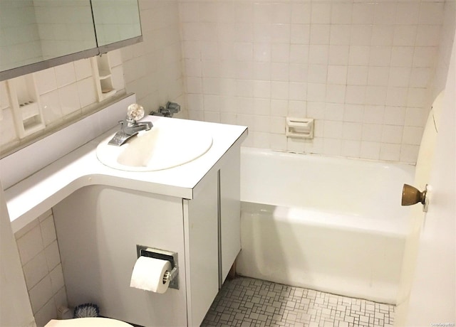 bathroom with a bathing tub, vanity, toilet, and tile patterned flooring