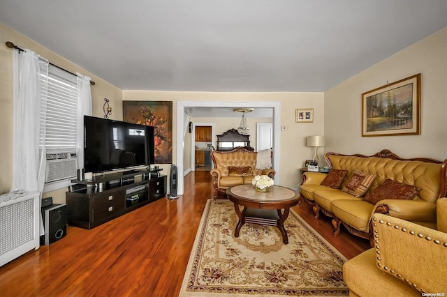 living room featuring radiator, cooling unit, and wood-type flooring