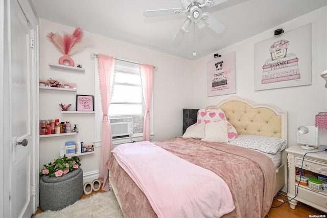 bedroom with ceiling fan, cooling unit, and light hardwood / wood-style flooring