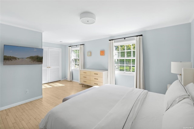 bedroom with light hardwood / wood-style floors and crown molding