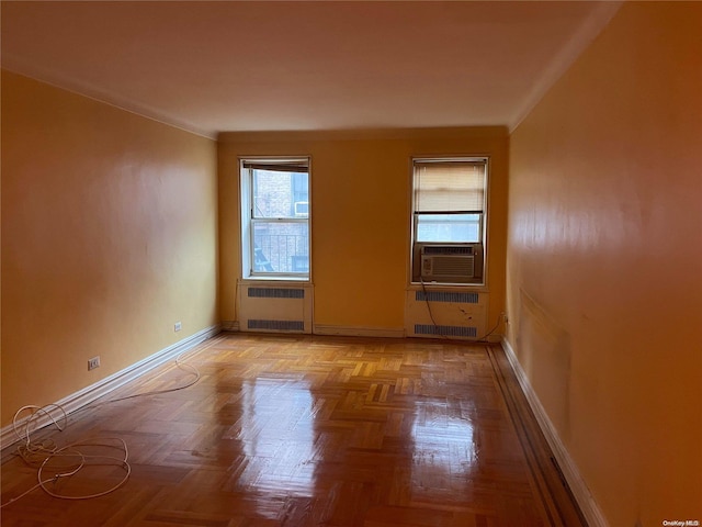 unfurnished room featuring a wealth of natural light, radiator heating unit, and light parquet floors