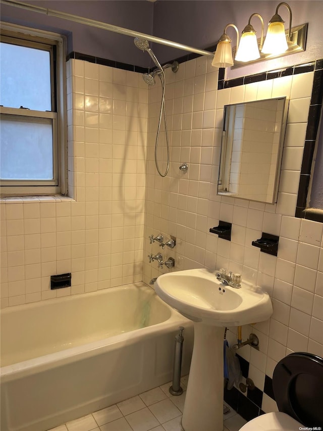 bathroom with tile patterned flooring, tiled shower / bath, and tile walls