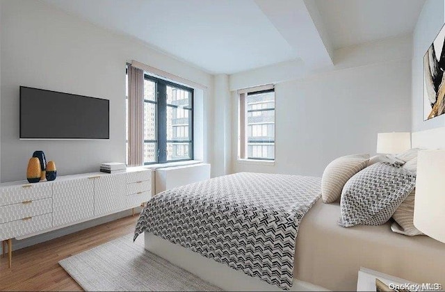 bedroom with hardwood / wood-style floors and beam ceiling