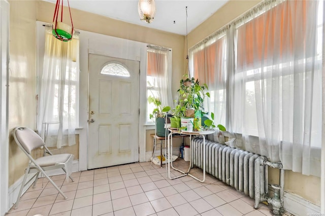 entryway with light tile patterned floors and radiator