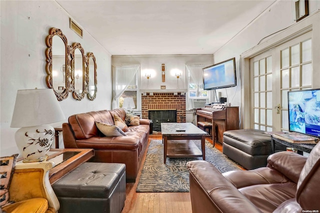 living room featuring hardwood / wood-style floors and a brick fireplace