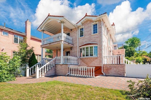 exterior space featuring a balcony and a front lawn