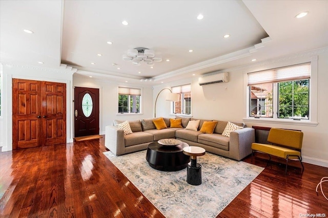 living room with dark hardwood / wood-style flooring, an AC wall unit, crown molding, and a wealth of natural light