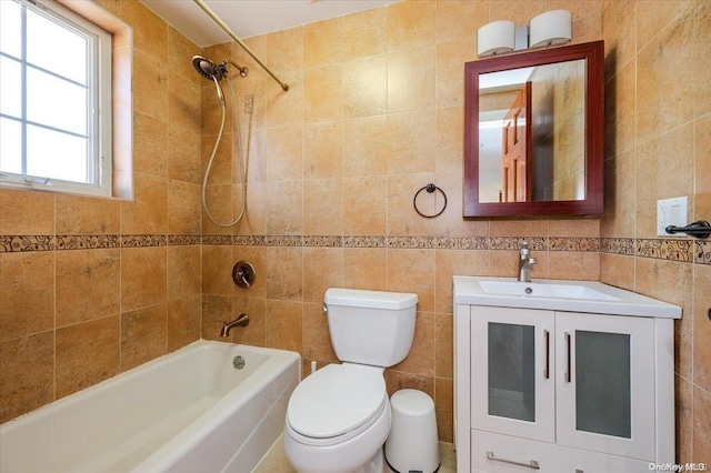 full bathroom featuring vanity, toilet, tile walls, and tiled shower / bath