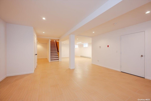 basement featuring light hardwood / wood-style floors and a baseboard heating unit