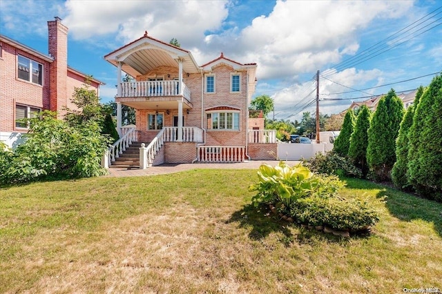 view of front of property featuring a porch, a balcony, and a front lawn