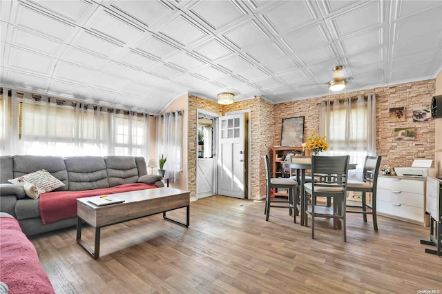 living room featuring brick wall and hardwood / wood-style flooring