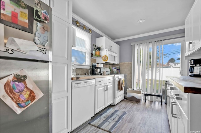 kitchen featuring a wealth of natural light, white cabinetry, and white appliances