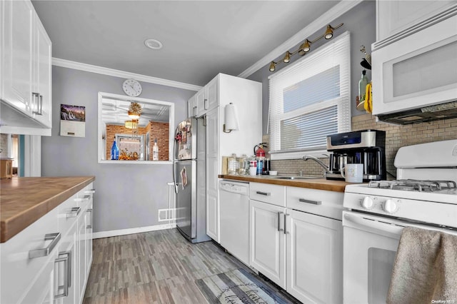 kitchen featuring white appliances, white cabinetry, ornamental molding, and sink